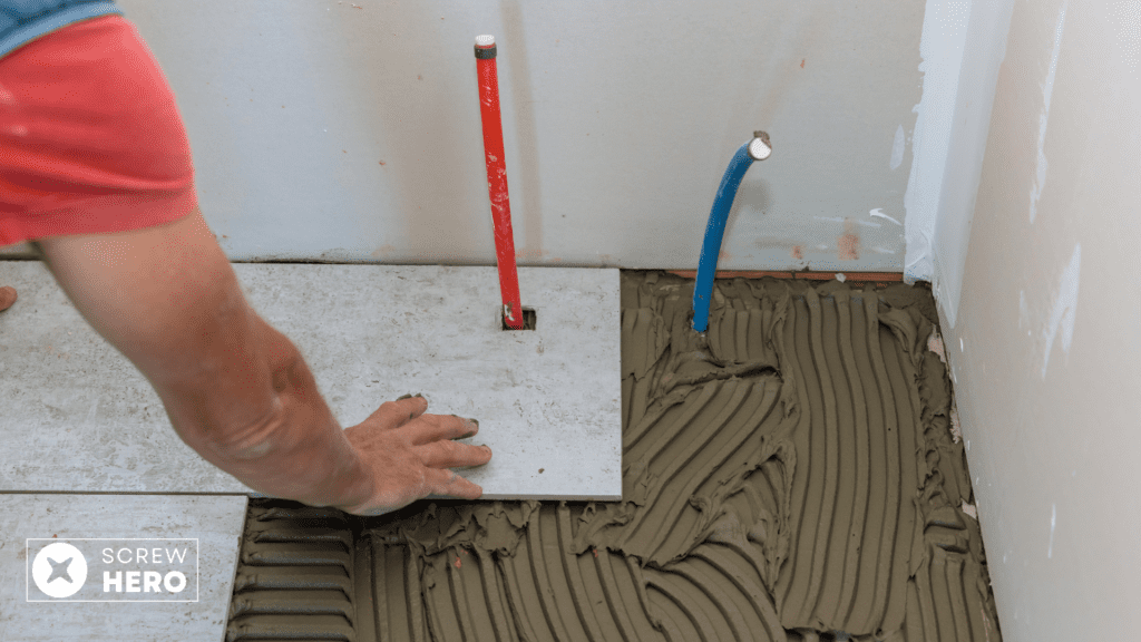 Professional tiler installing floor tiles in a living room.