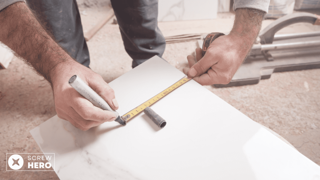 Professional tiler measuring and cutting tiles for installation.